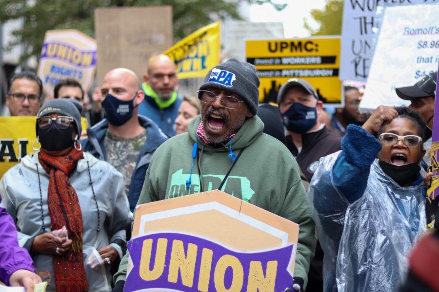 A protester rallies with a crowd of UPMC employees on Grant Street during Thursday’s UPMC Essential Worker Strike in Downtown. 
