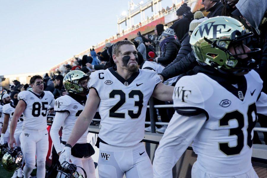 Wake+Forest+tight+end+Brandon+Chapman+%2823%29+high-fives+fans+with+his+teammates+after+defeating+Boston+College+at+Alumni+Stadium+in+Boston+on+Saturday.+%0A