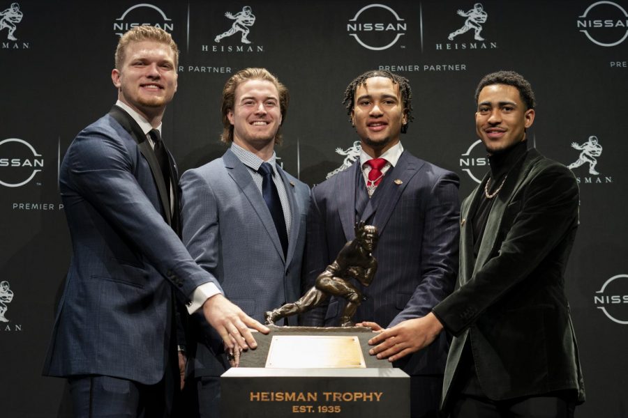 Heisman trophy finalists, from left, Michigan defensive end Aidan Hutchinson, Pittsburgh quarterback Kenny Pickett, Ohio State quarterback C.J. Stroud, and Alabama quarterback Bryce Young stand for a photo with the Heisman Trophy before attending the award ceremony, Saturday, Dec. 11, 2021, in New York.