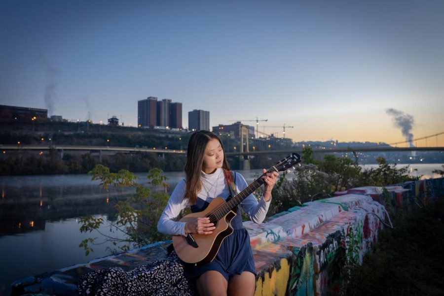 Yunge Xiao, a sophomore statistics and sociology major, sits at Color Park with her guitar on Nov. 6. 