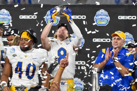 Pitt quarterback Kenny Pickett (8) holds up the ACC Championship trophy as the Pitt Panthers are showered in confetti.