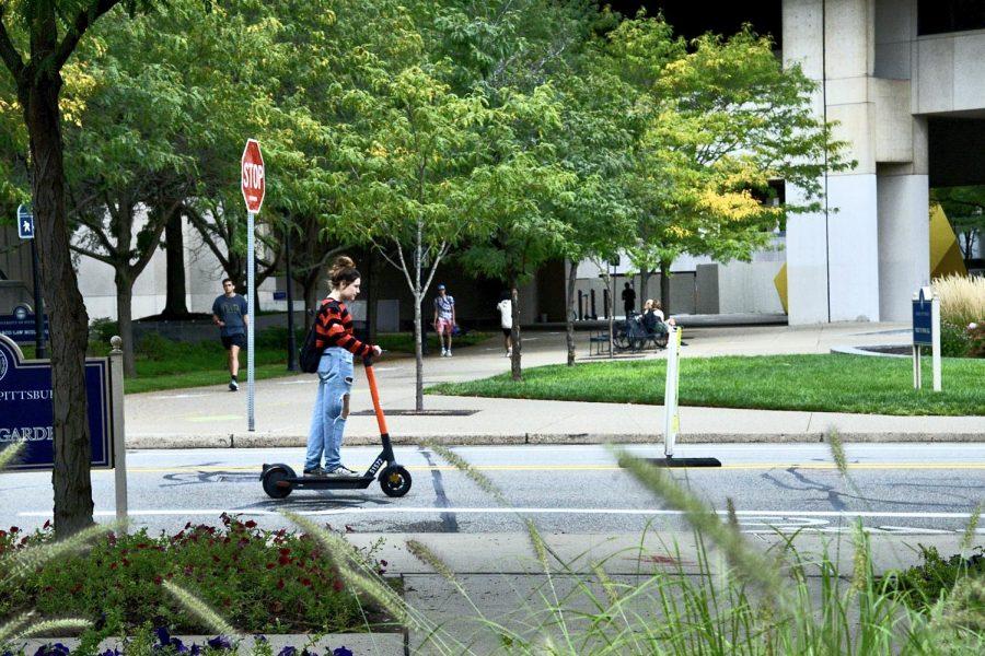 A student rides a Spin scooter on campus in September.