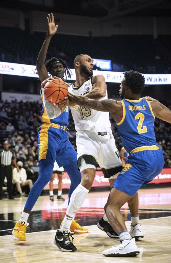 Pitt graduate student forward Mouhamadou Gueye (15), left, and sophomore guard Femi Odukale (2), right, play defense against Wake Forest graduate student forward Dallas Walton (13) during Wednesday’s game in Winston-Salem, North Carolina. 
