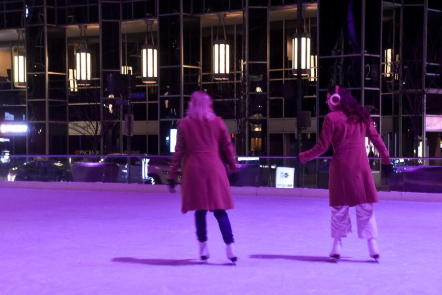 Two people skate around PPG Place ice skating rink Sunday night.