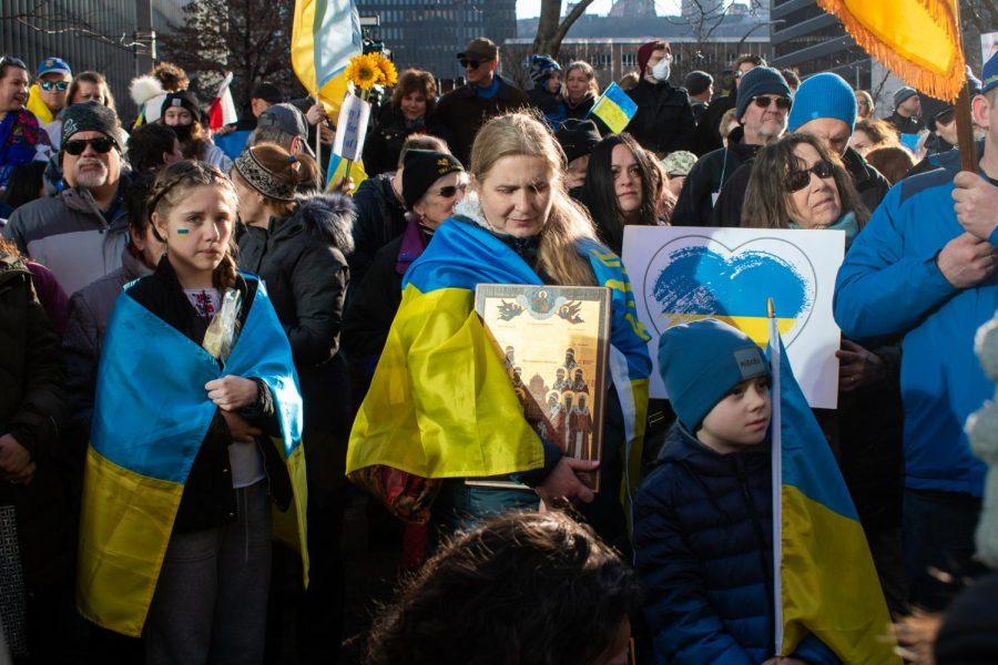 People silently listen to speakers at a rally Downtown in support of Ukraine on Sunday evening.