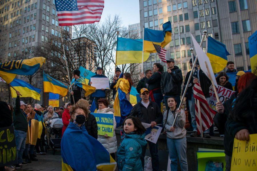 Participants hold signs and flags at a rally Downtown in support of Ukraine on Sunday evening.