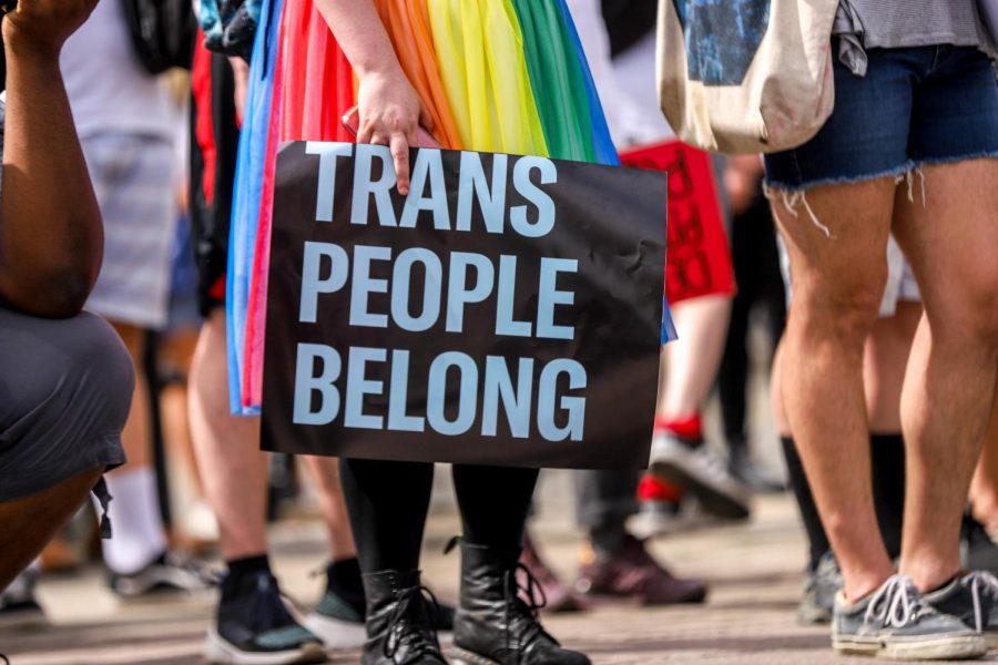 A protester holds a “Trans People Belong” sign during a June 2020 protest.
