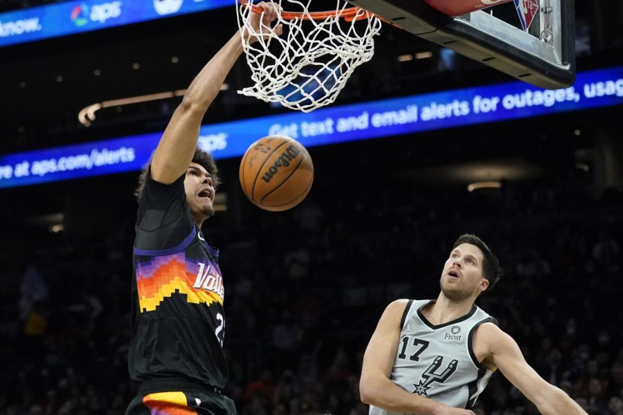 Phoenix Suns forward Cameron Johnson dunks as San Antonio Spurs forward Doug McDermott (17) looks on during the second half of an NBA basketball game Jan. 30 in Phoenix. 