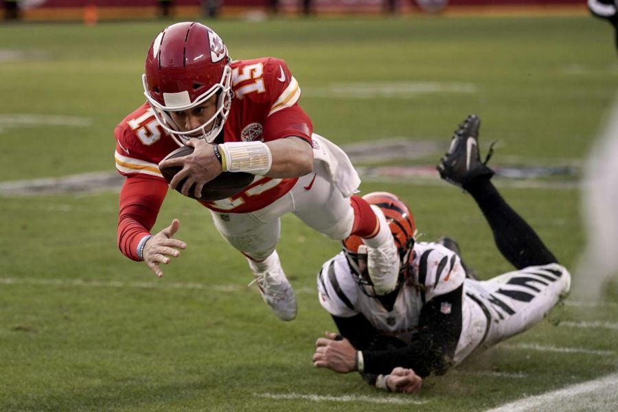 Kansas City Chiefs quarterback Patrick Mahomes (15) dives after running the ball ahead of Cincinnati Bengals defensive end Trey Hendrickson, right, during the second half of the AFC championship NFL football game, Sunday, Jan. 30, 2022, in Kansas City, Missouri. 