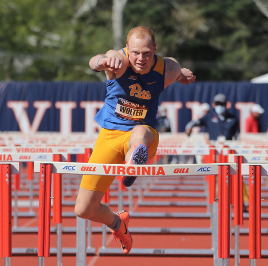 Pitt graduate student Felix Wolter jumps over a hurdle at a track & field meet. 