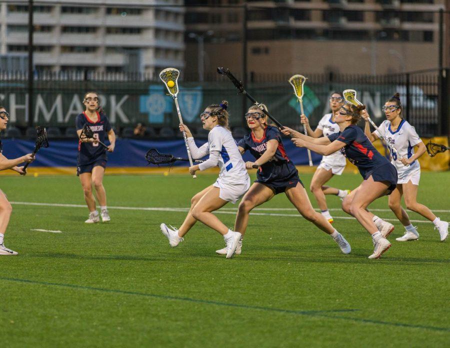 Pitt freshman attacker Sydney Naylor is chased by Duquesne lacrosse players during the first Pitt womens lacrosse game in program history.