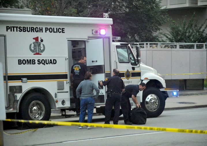 Members of the City and Pitt police stand by a bomb squad truck on Forbes Avenue.
