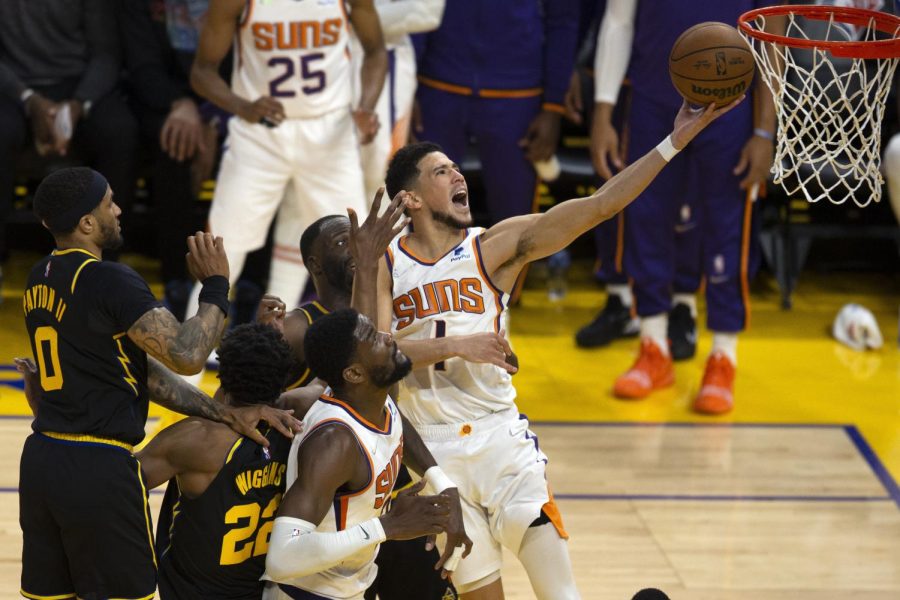 Phoenix Suns guard Devin Booker (1) drives to the basket through a trio of Golden State Warriors defenders during Wednesday’s game in San Francisco. 
