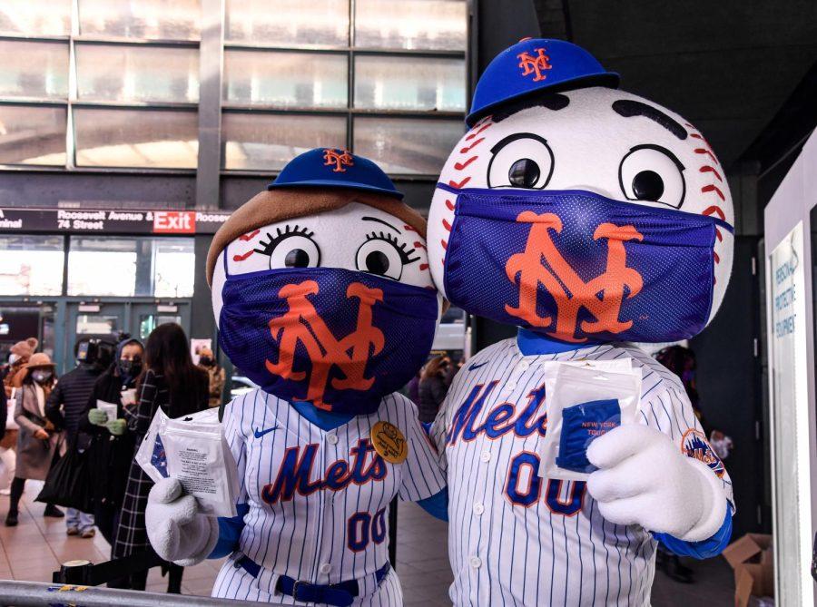 New York Mets mascots Mrs. Met, left, and Mr. Met hand out masks to passerbys outside of a subway station last April. 
