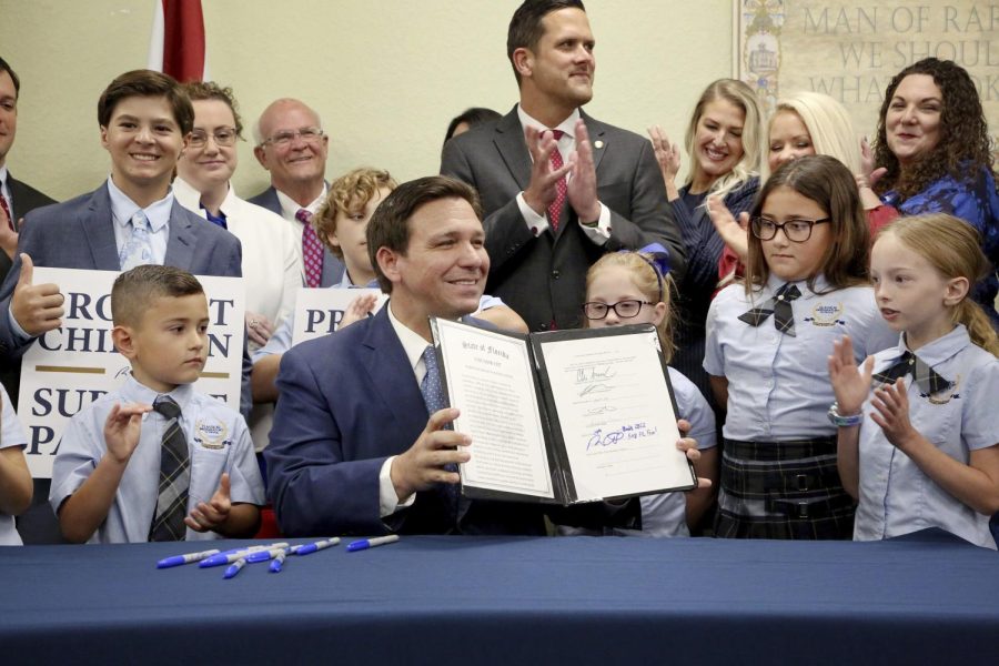 Florida+Gov.+Ron+DeSantis+displays+the+signed+Parental+Rights+in+Education%2C+aka+the+Dont+Say+Gay+bill%2C+flanked+by+elementary+school+students+during+a+news+conference+on+Monday%2C+March+28%2C+2022%2C+at+Classical+Preparatory+school+in+Shady+Hills.