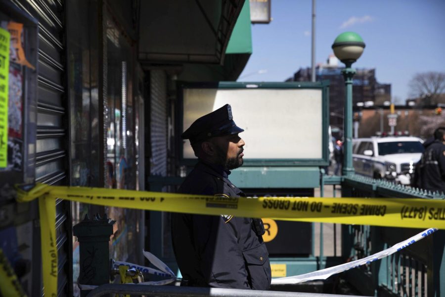 A police officer stands watch at the entrance of 36th Street Station after multiple people were shot on a subway train in Brooklyn on Tuesday.