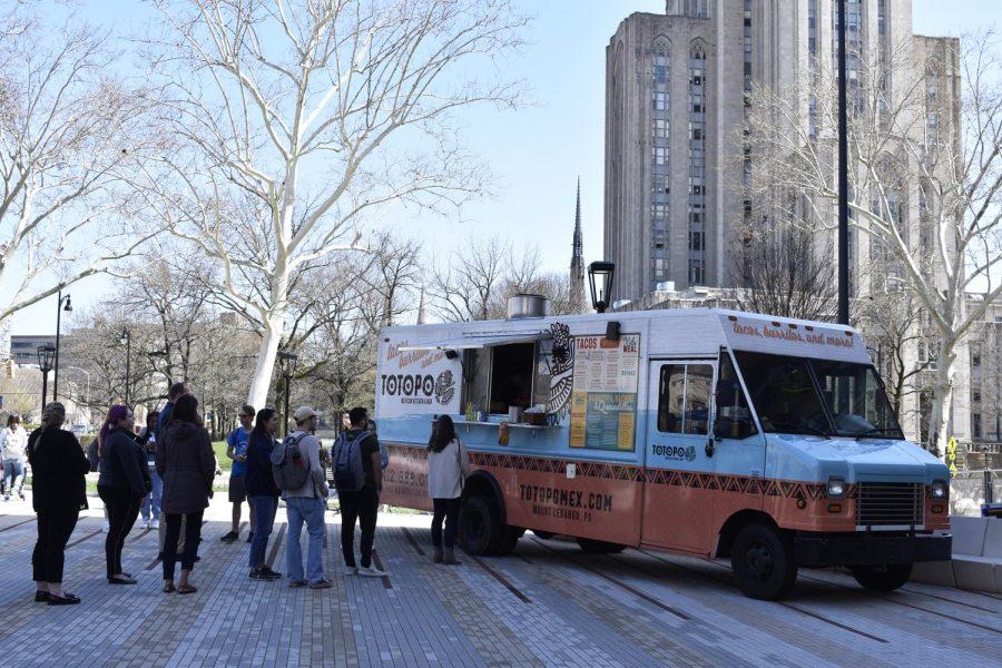 Patrons wait in line to order from the Totopo Cocina & Cantina food truck at Thursday’s Food Truck Roundup outside of the William Pitt Union. 