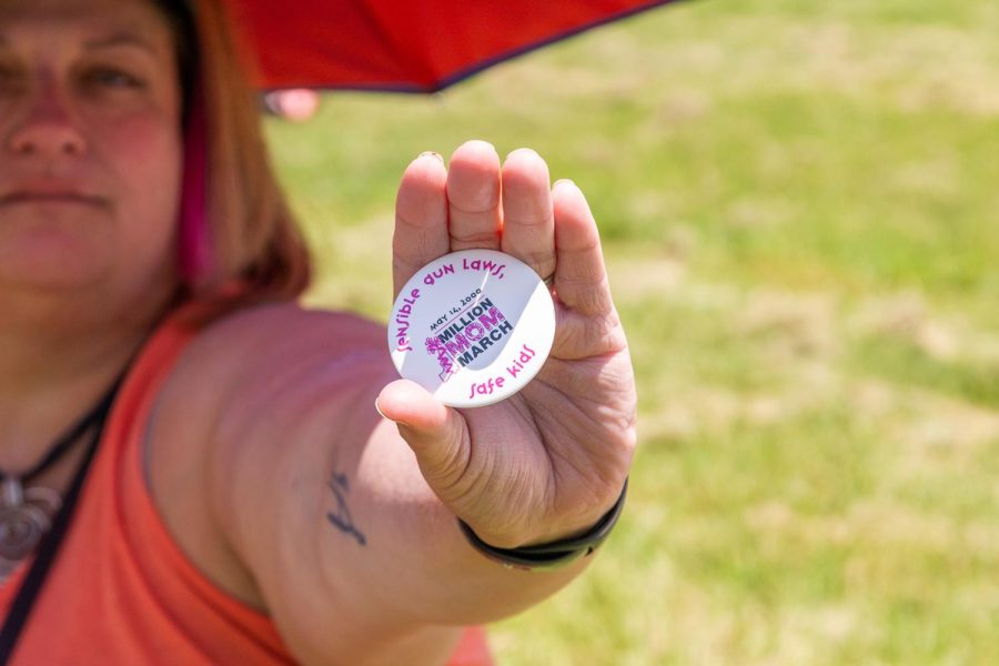 An attendee at Saturday’s “March for Our Lives” rally in Schenley Park holds up a pin that reads “Sensible gun laws, safe kids” from the Million Mom March in 2000. 