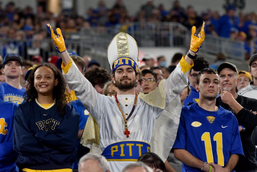 Carson Zaremski dressed as the pope poses for a photo in a crowd of Pitt fans during the football ACC Championship Game against Wake Forest University in Charlotte, N.C.