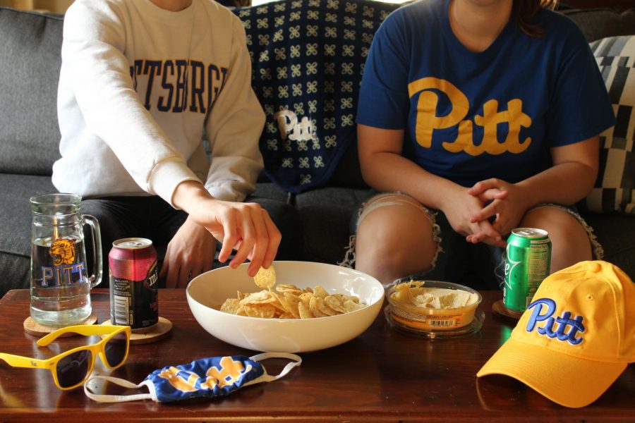 Students eat and watch a football game at home.