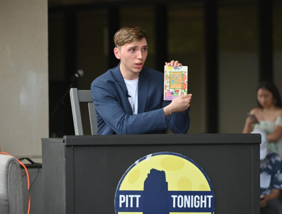 Nick Cassano shows the crowd a children’s book at Pitt Tonight’s season eight premiere outside of Posvar Hall on Friday.
