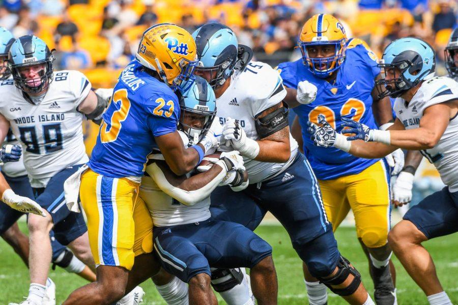 Pitt players tackle a Rhode Island player during Pitt footballs game against Rhode Island Saturday afternoon.