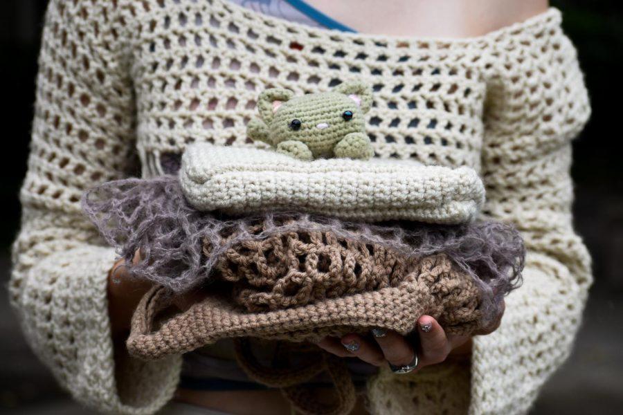 Julianna Paul holds a pile of her knitting and crochet projects.