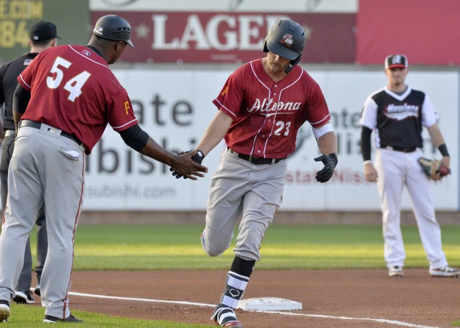 Altoona Curve coach Salvador Paniagua, left, congratulates Logan Hill on his fourth-inning home run against the Erie SeaWolves during a Double-A baseball game in Erie, Pa. on July 12, 2019. 