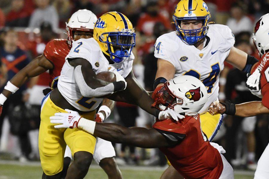 Pittsburgh running back Israel Abanikanda (2) attempts to get away from the grasp of Louisville defensive lineman YaYa Diaby, front right, during the first half of an NCAA college football game in Louisville, Ky., Saturday, Oct. 22, 2022.