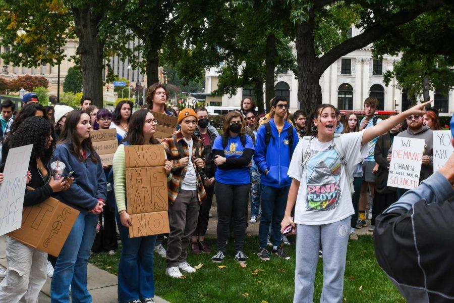 A Pitt student speaks at a protest against sexual violence outside of the Cathedral of Learning Friday afternoon.