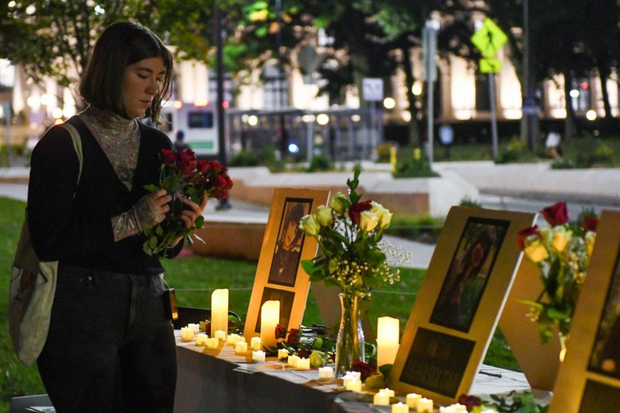 A student leaves flowers at a candlelight vigil for Mahsa Amini and other victims of the Iranian “morality police” outside the William Pitt Union last Tuesday evening.
