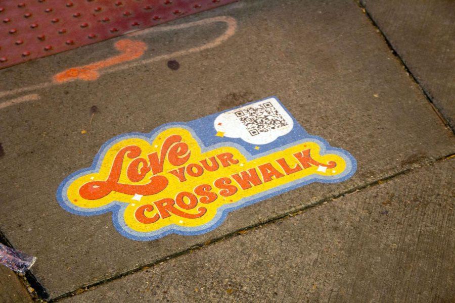 A “Love Your Crosswalk” sign at a crosswalk on Forbes and Oakland Avenues. 
