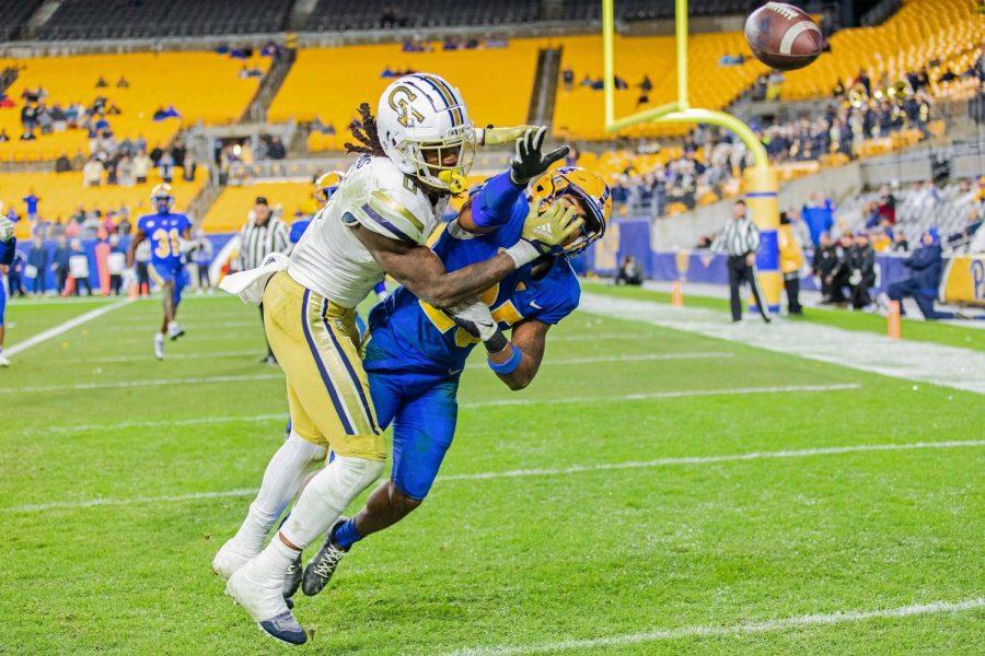 A Georgia Tech player, left, and Pitt senior defensive back A.J. Woods (25) reach for the ball during Saturday’s game. 
