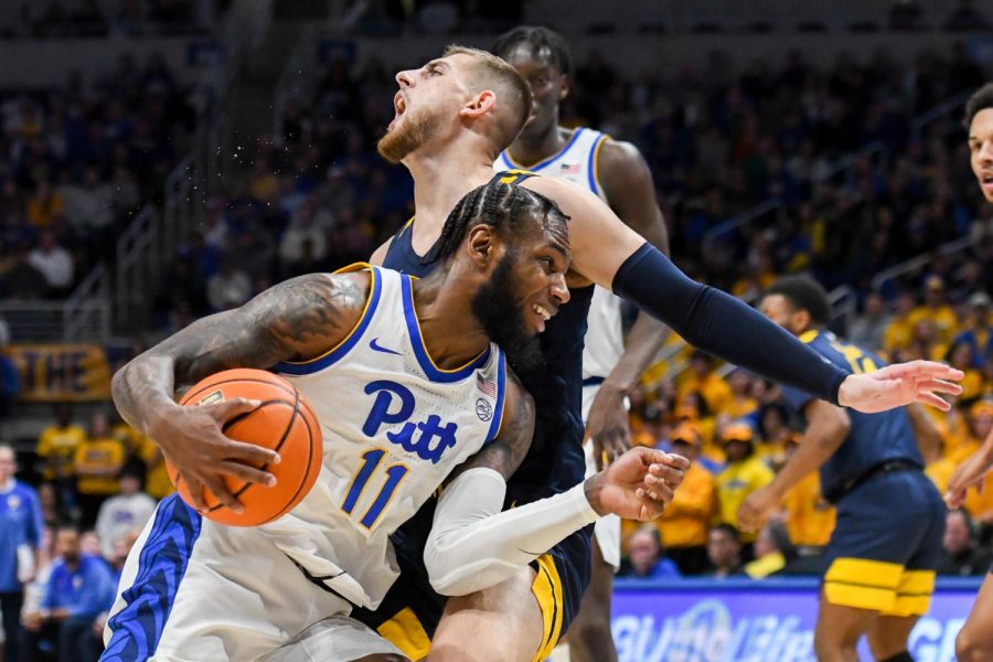 Graduate+student+guard+Jamarius+Burton+%2811%29+knocks+over+a+West+Virginia+player+as+he+attempts+to+score+during+Pitt+mens+basketballs+game+against+West+Virginia+on+Nov.+11%2C+2022.