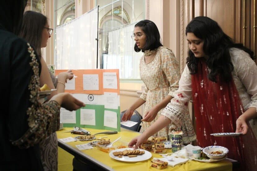 Pitt students hand out food at the Indian cultural table during the Muslim Student Association’s Halal-a-palooza in the William Pitt Union on Friday evening. 