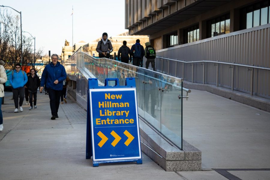 A sign outside of Hillman Library advertising the new entrance to the first floor.