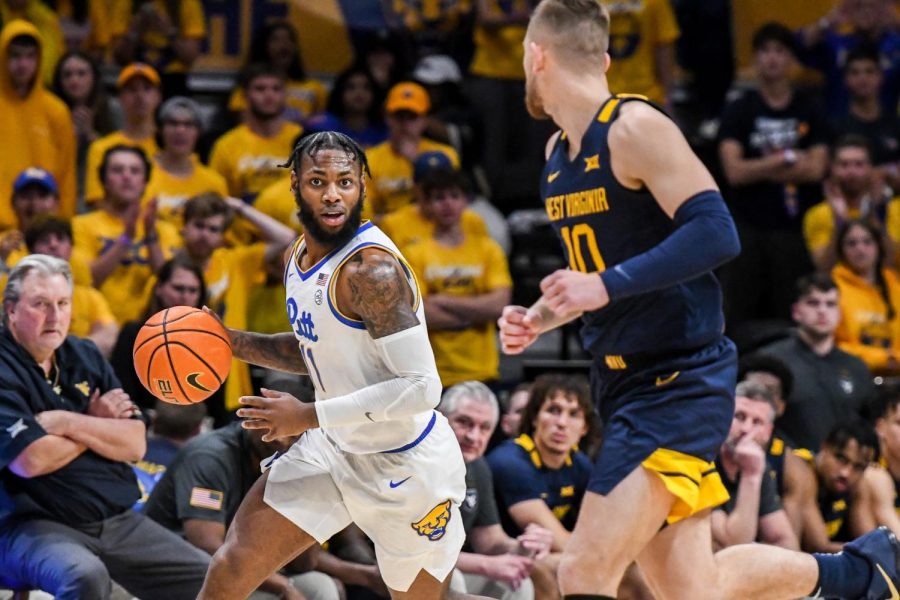 Graduate+student+guard+Jamarius+Burton+%2811%29+dribbles+the+ball+down+the+court+during+the+Pitt+mens+basketball+game+against+West+Virginia+on+Nov.+11.