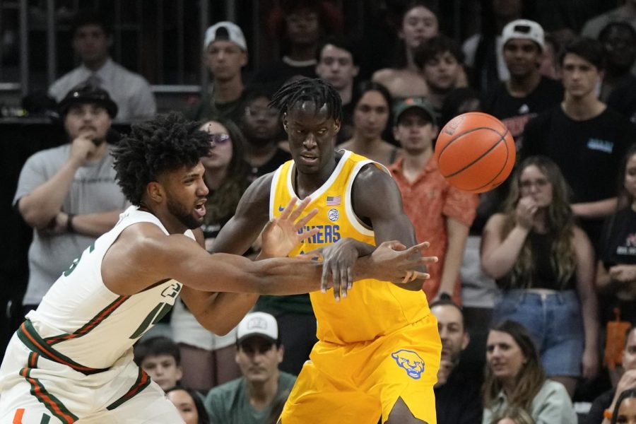 Miami forward Norchad Omier (15) passes the ball past Pittsburgh center Federiko Federiko during the first half of an NCAA college basketball game, Saturday, March 4, 2023, in Coral Gables, Fla. 