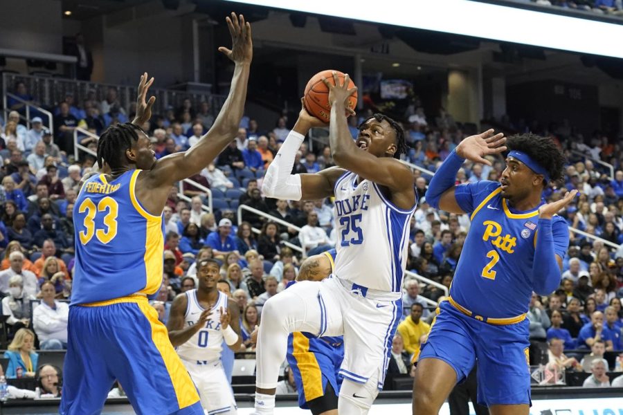 Duke forward Mark Mitchell (25) drives between Pittsburgh forward Blake Hinson (2) and center Federiko Federiko (33) during the first half of an NCAA college basketball game at the Atlantic Coast Conference Tournament in Greensboro, N.C., Thursday, March 9, 2023. 
