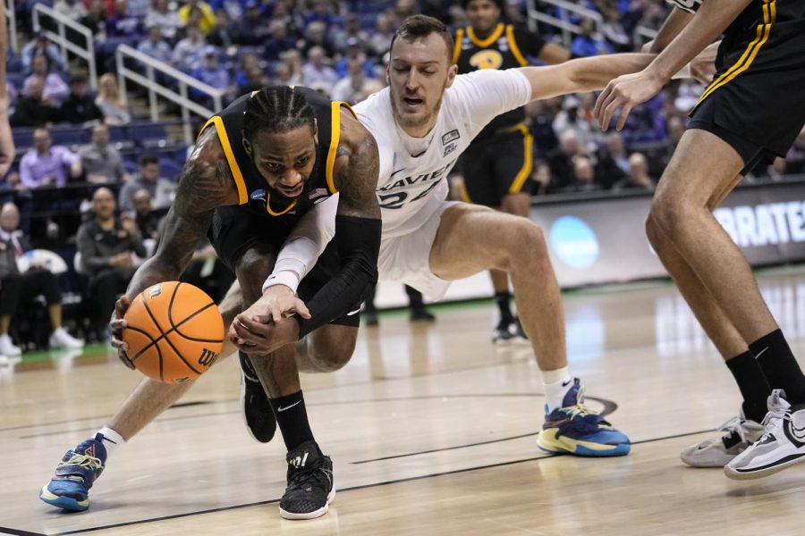 Pittsburgh guard Jamarius Burton (11)a and Xavier forward Jack Nunge (24) reach for a loose ball during the first half of a second-round college basketball game in the NCAA Tournament on Sunday, March 19, 2023, in Greensboro, N.C. 