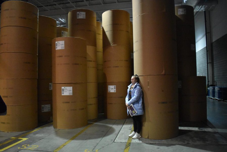 Grace DeLallo stands next to containers of newspaper rolls at the Pittsburgh Post-Gazette printing facility in 2022.