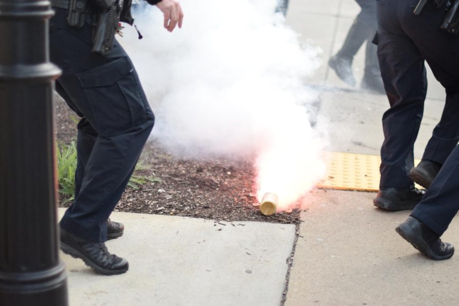 A smoke bomb lands on the ground at the second of two protests against a debate featuring Michael Knowles on campus Tuesday evening.