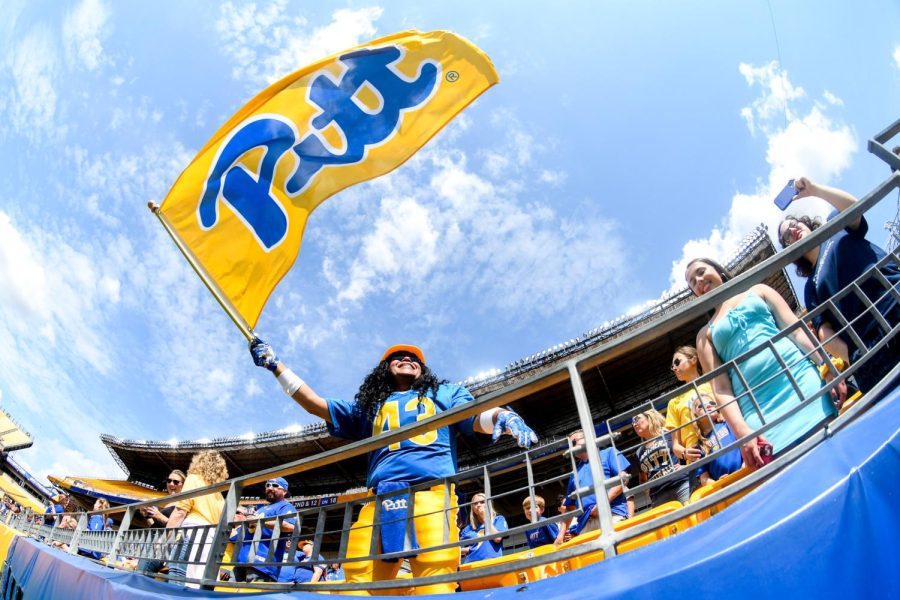 A fan waves a flag at the Pitt football spring game at Acrisure Stadium.