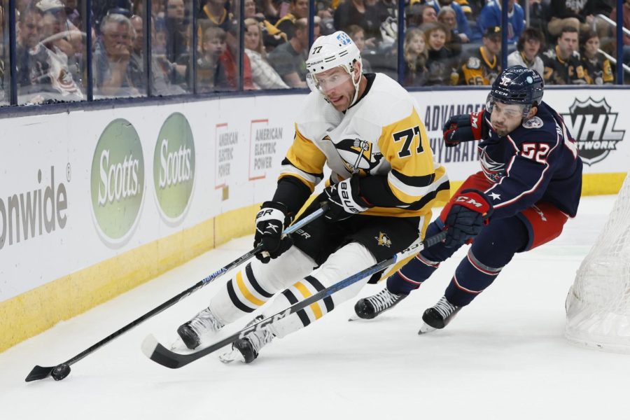 Pittsburgh Penguins Jeff Carter, left, carries the puck behind the net as Columbus Blue Jackets Emil Bemstrom defends during the third period of an NHL hockey game Thursday, April 13, 2023, in Columbus, Ohio. 