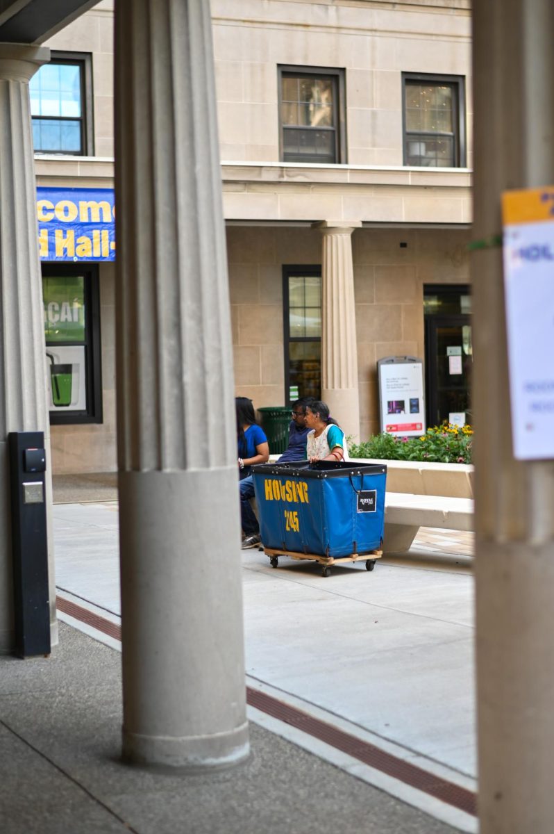 A family sits outside of Holland Hall in the quad with a housing cart on Tuesday afternoon.
