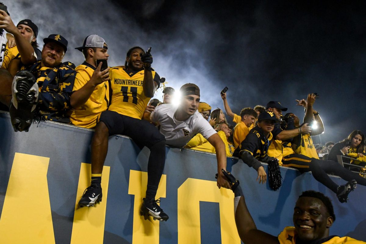 West Virginia football players and fans celebrate after WVU defeated Pitt 17-6 at Mountaineer Field Saturday night.