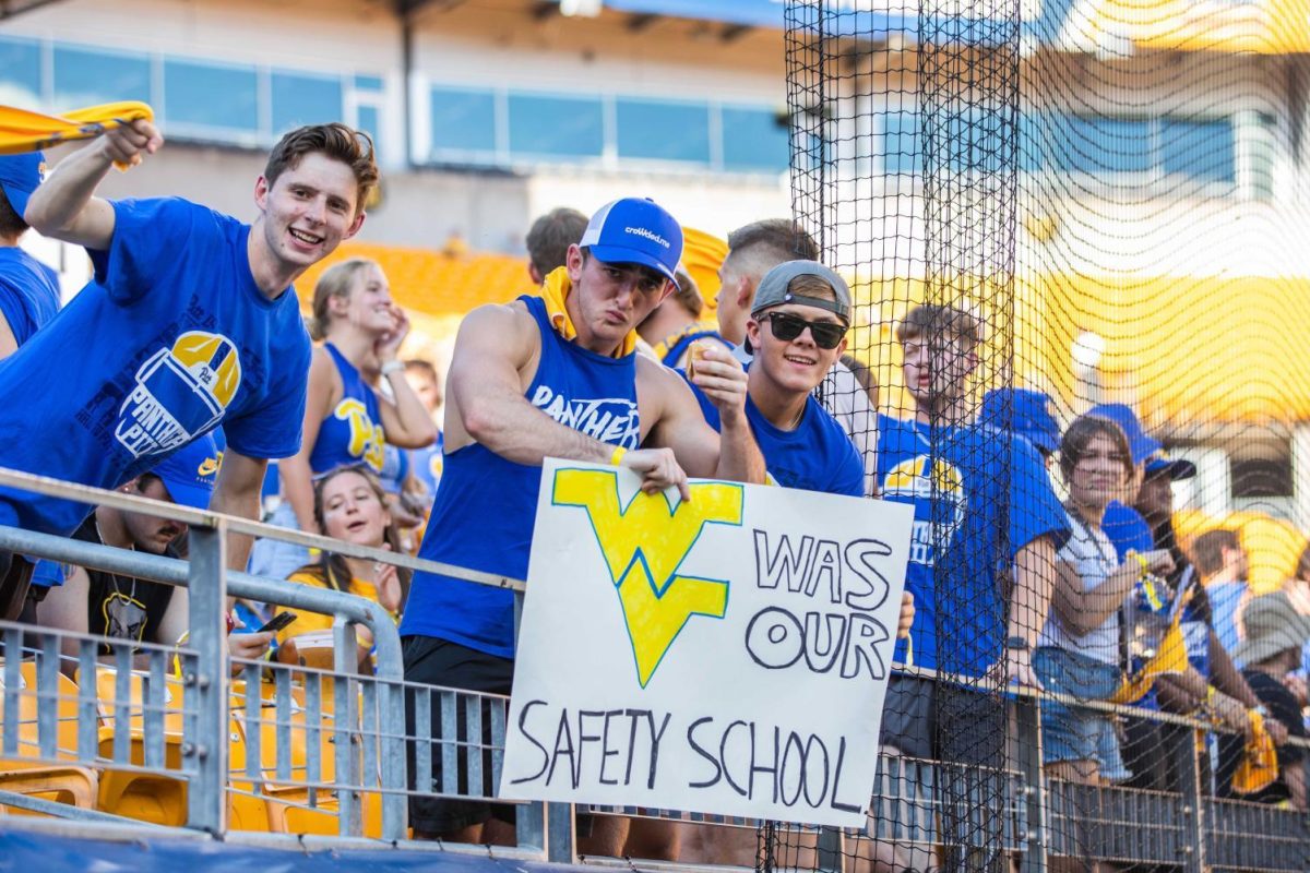 Pitt fans show off a sign that reads WV was our safety school in the stands of Acrisure Stadium before the Backyard Brawl on Thursday.