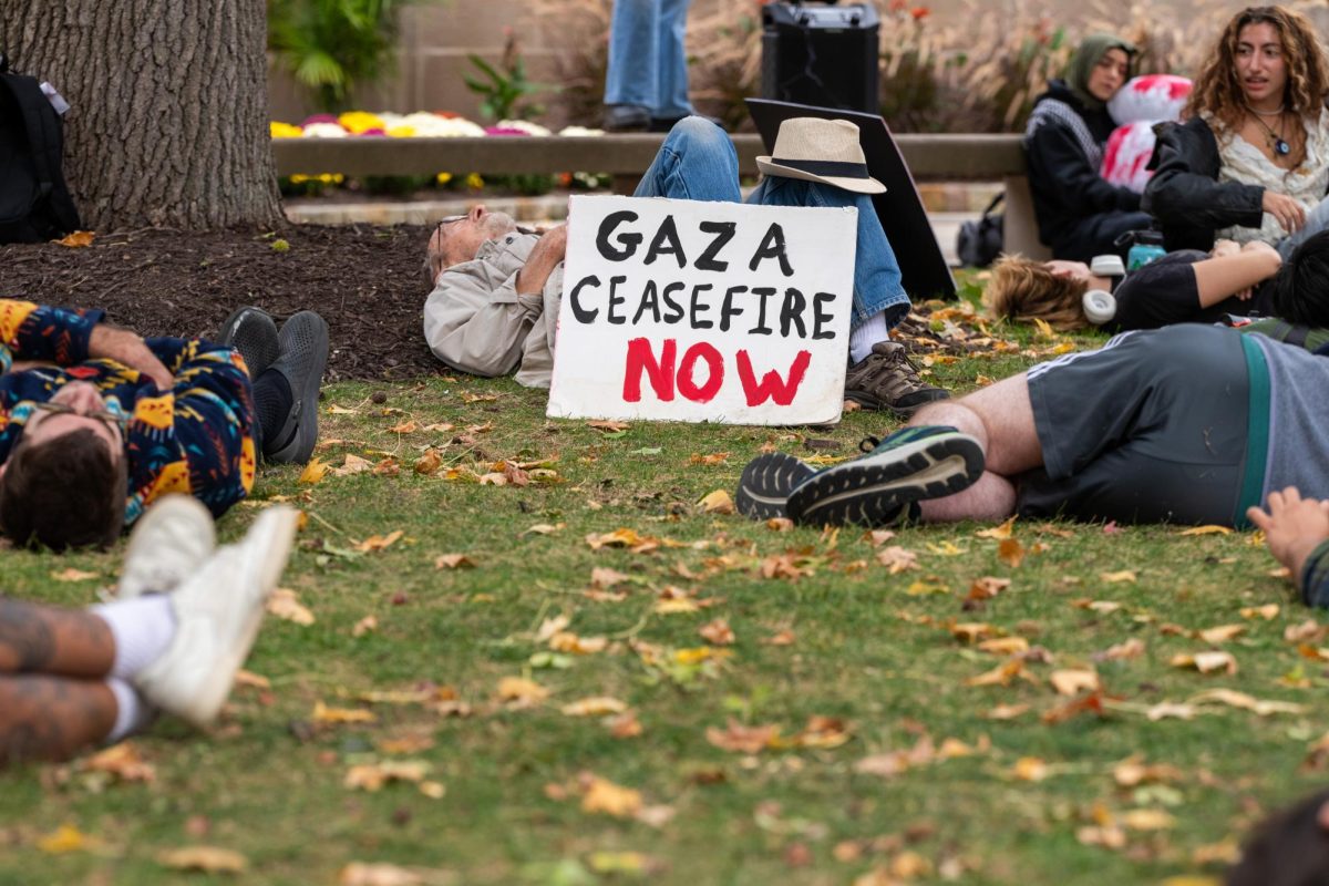 Students and community members lay on the grass in support of Palestine during a “die in” protest in front of the Cathedral of Learning on Wednesday.