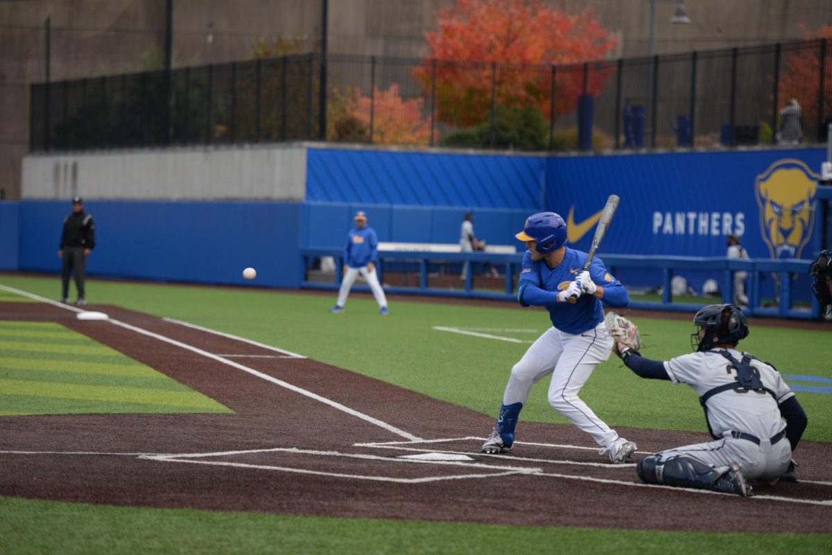 A Pitt baseball player amid a pitch during the game against Akron in Charles L. Cost Field on Oct. 20.
