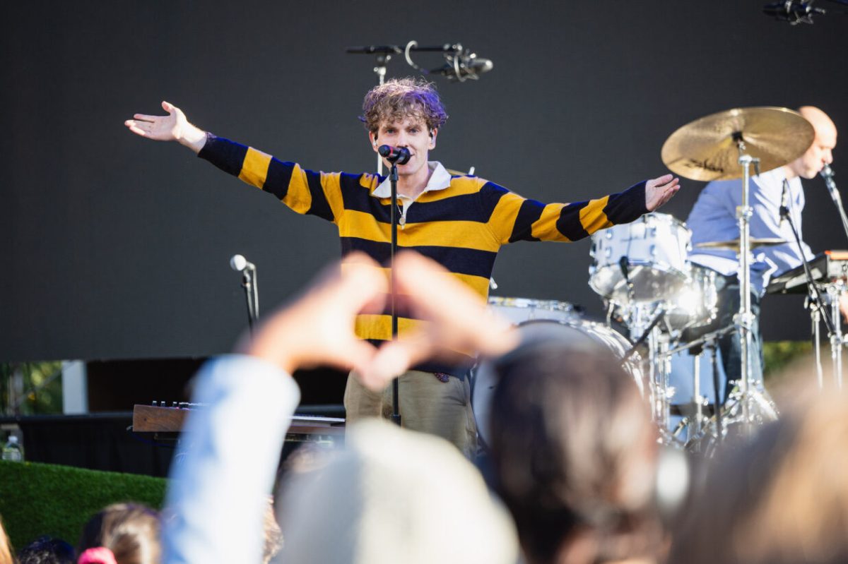 A fan makes a heart with their hands during COIN’s performance at Fall Fest at Schenley Drive on Sunday.
